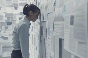 Woman leaning on a wall covered in charts and graphs