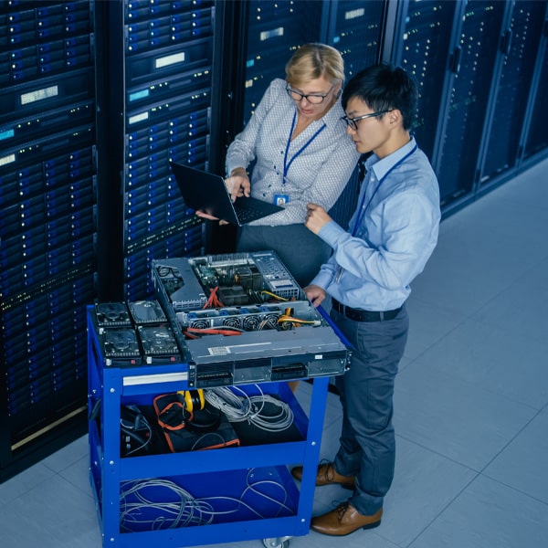 A woman and man standing next to a supercomputer