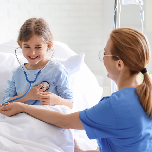 Female doctor working with little girl in hospital room